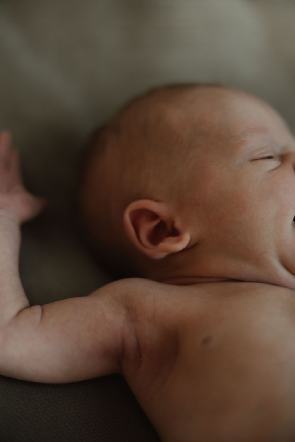 Close-up profile view of a sleeping baby against a soft blurred background.