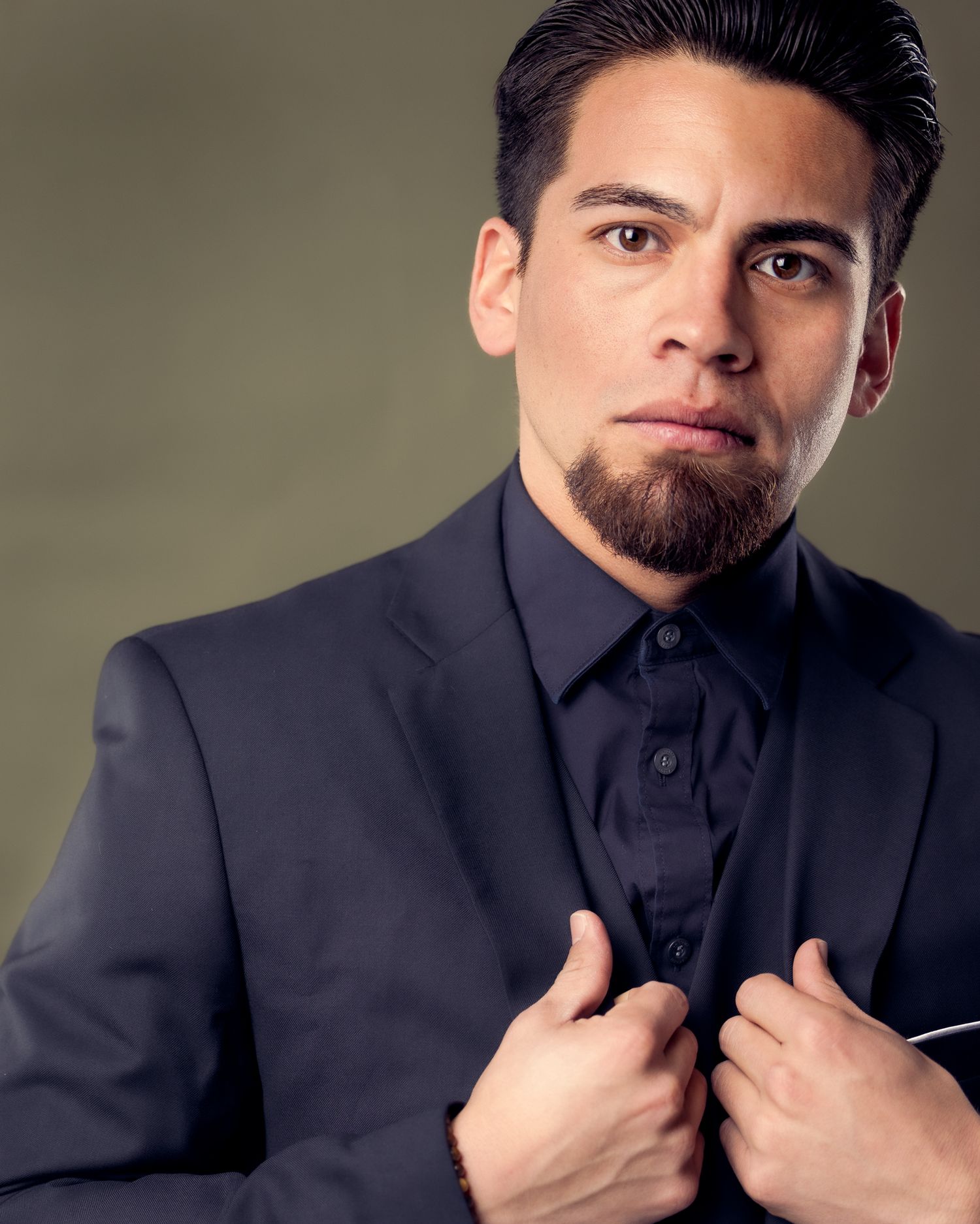 A set of continuous photos showing someone in a dark jacket adjusting their collar against a neutral background.