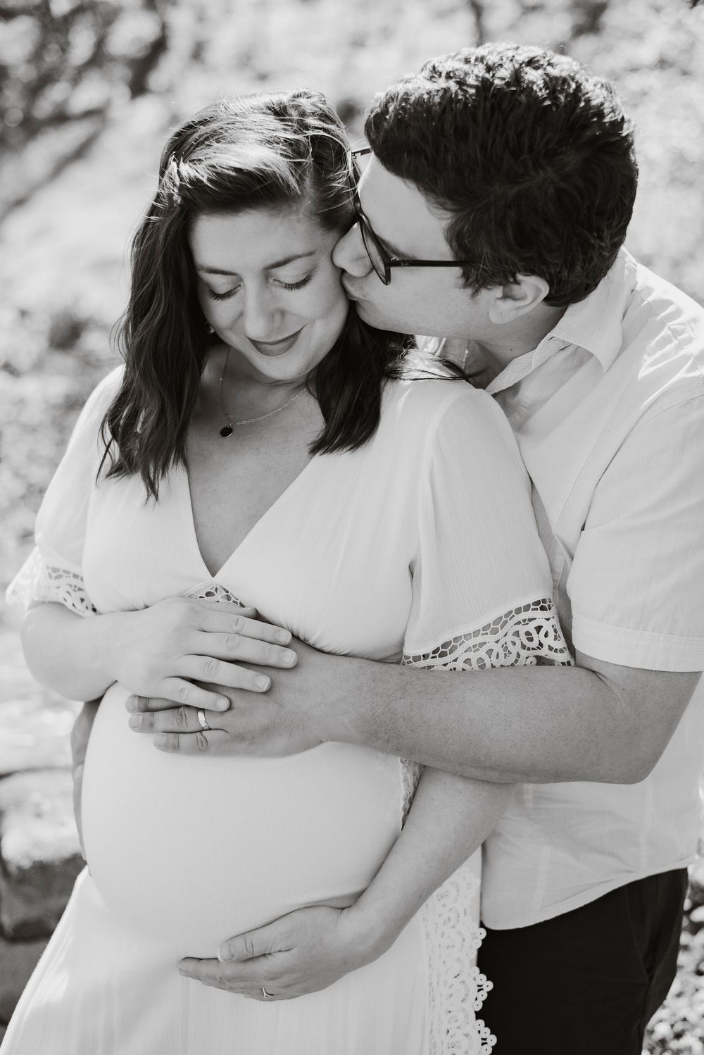 A couple posing for maternity photos at home.