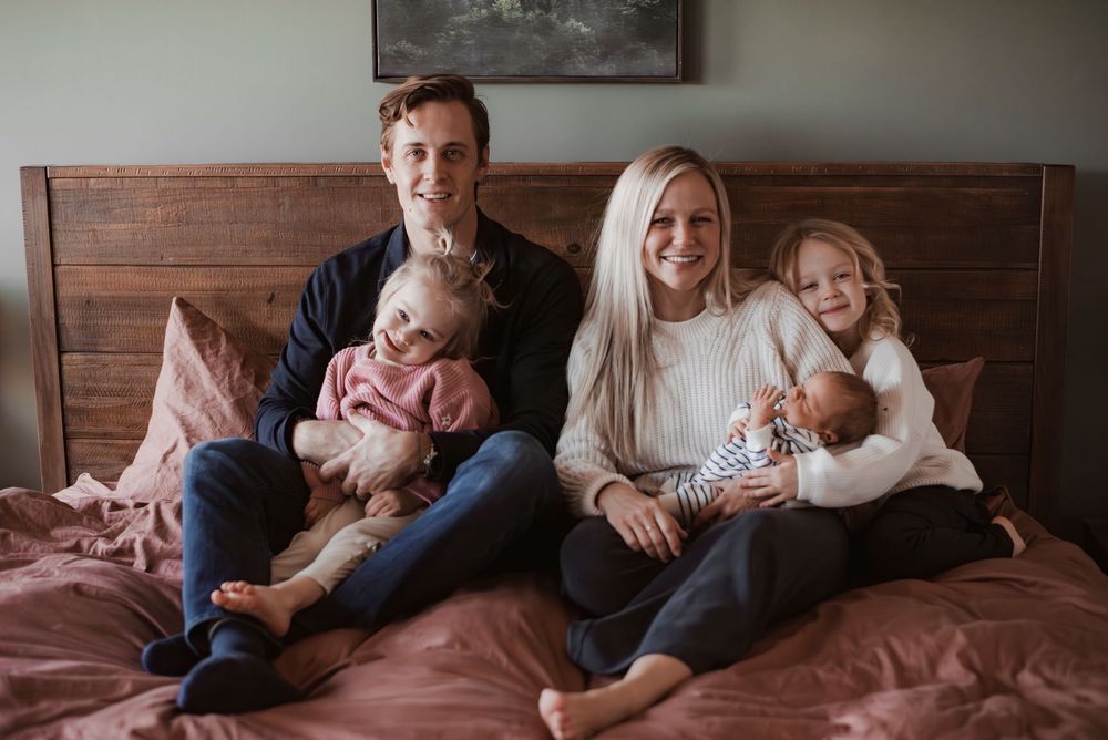 A family of four posing together at home.