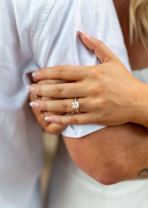Close-up shots of hands displaying an engagement ring against a white shirt background. proposal engagement fort worth dallas texas