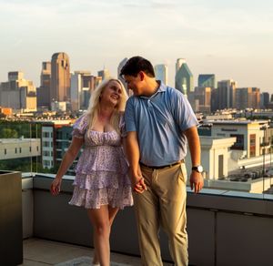 Couple sharing a romantic moment on a rooftop with the downtown Minneapolis skyline at sunset in the background. proposal engagement TX