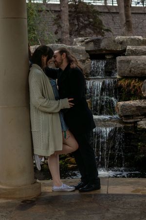 Romantic moment by a cascading waterfall with stone pillars. proposal engagement fort worth dallas texas. couples session