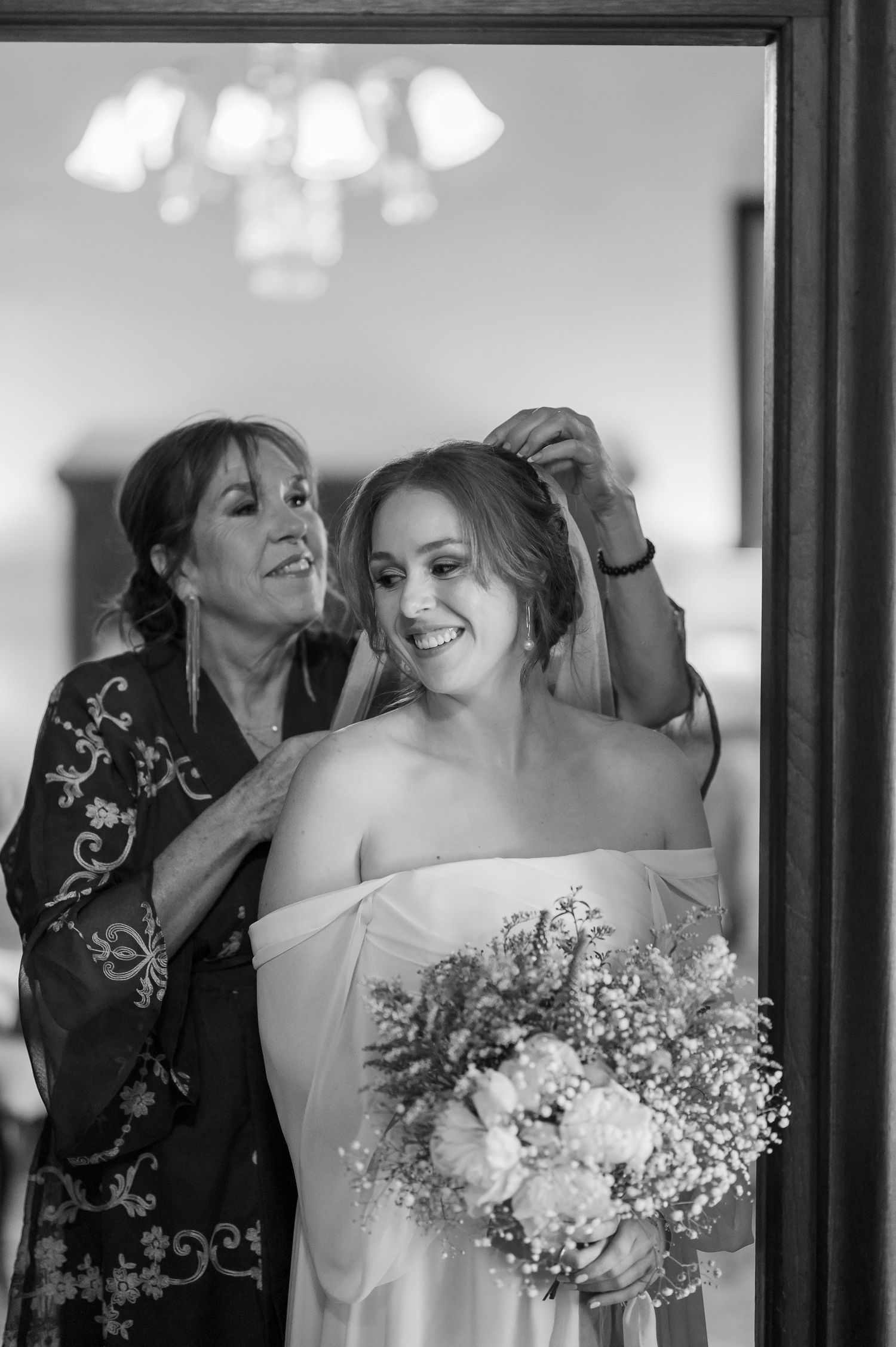 Wedding party sharing joyful moment with flowers in formal attire.