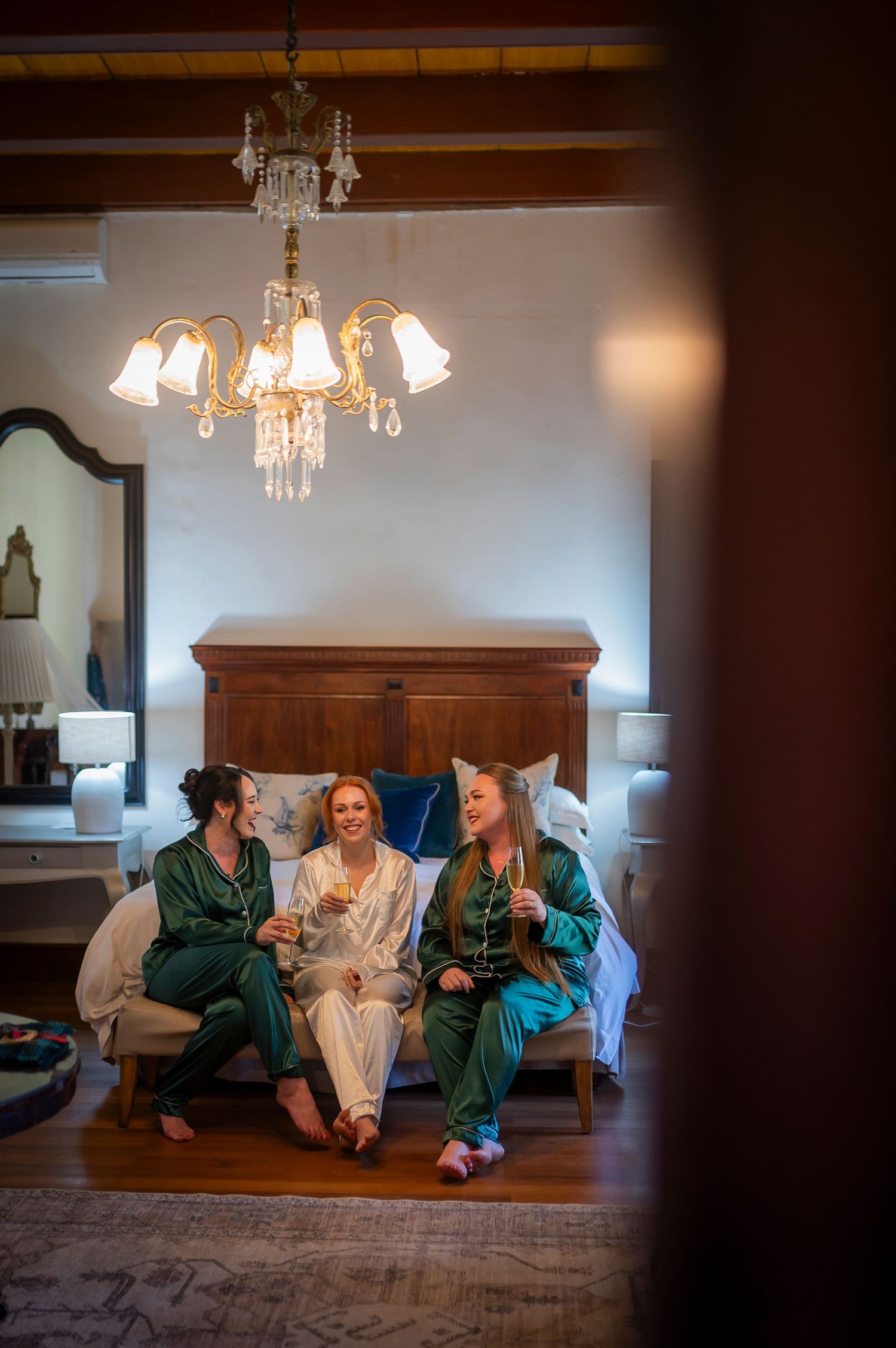 Group relaxing together on a beige sofa under chandelier lighting.
