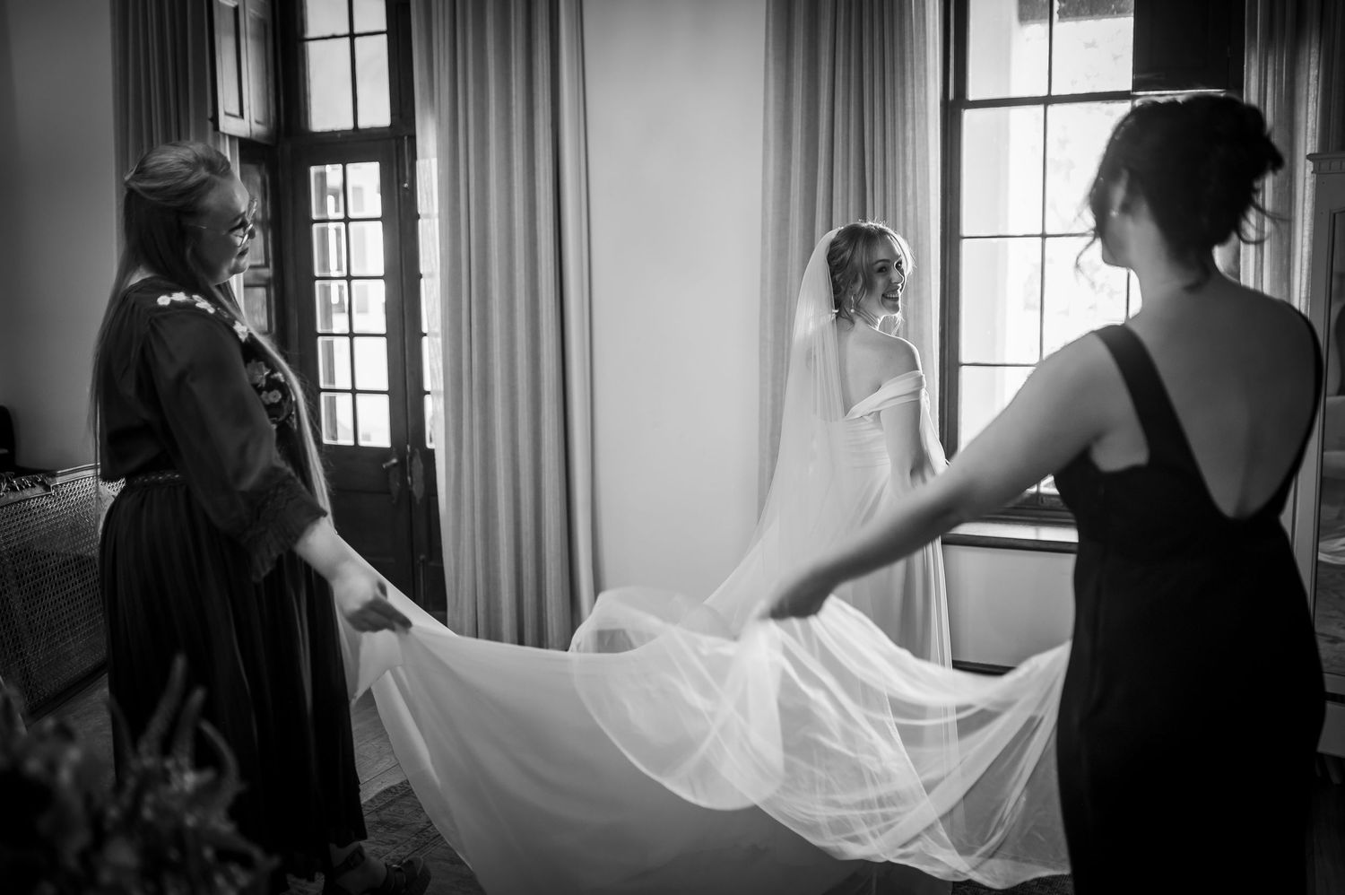 Elegant wedding preparation scene in black and white with window light.