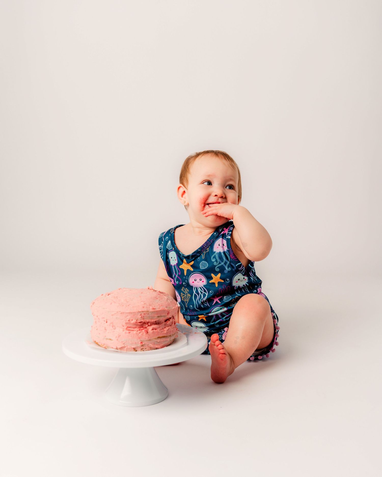 Milestone photography series showing a child sitting on a white chair with a large gold number 2 balloon in consecutive poses.