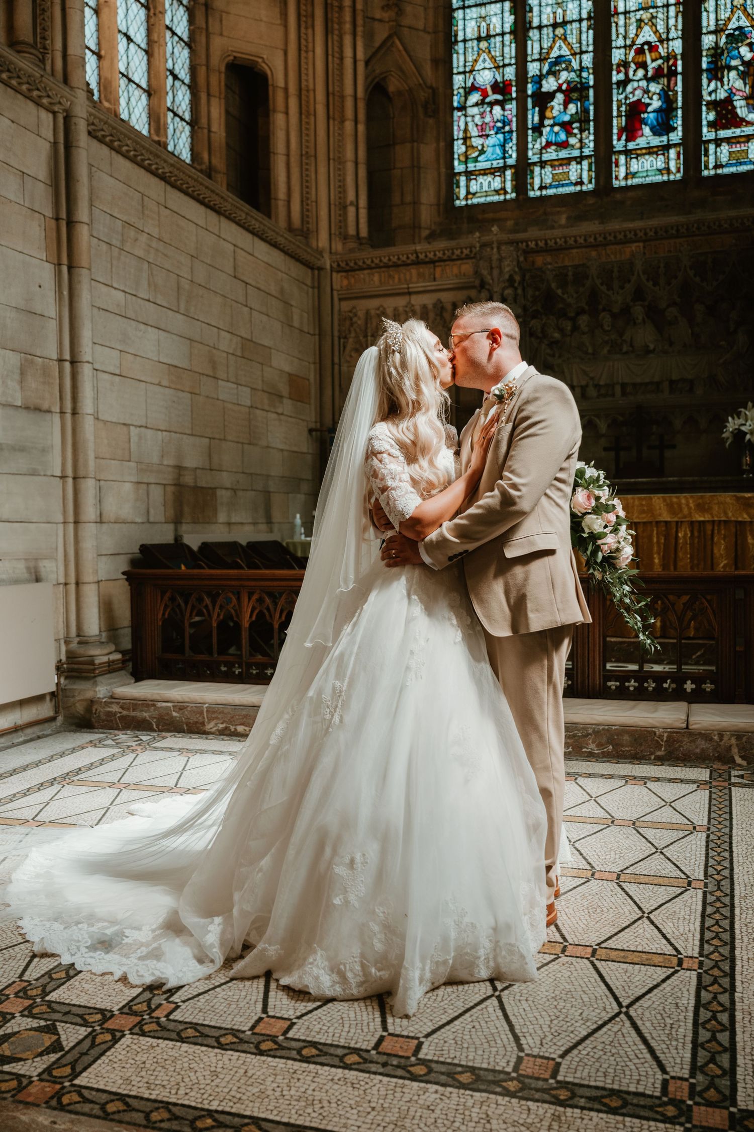 Wedding photos in a church with beautiful stained glass windows and architectural details.