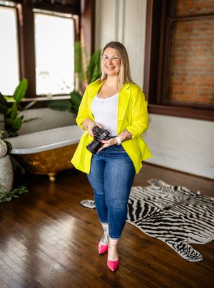 A bright yellow blazer paired with blue jeans and pink heels creates a stylish look in a room with hardwood floors and a zebra rug.