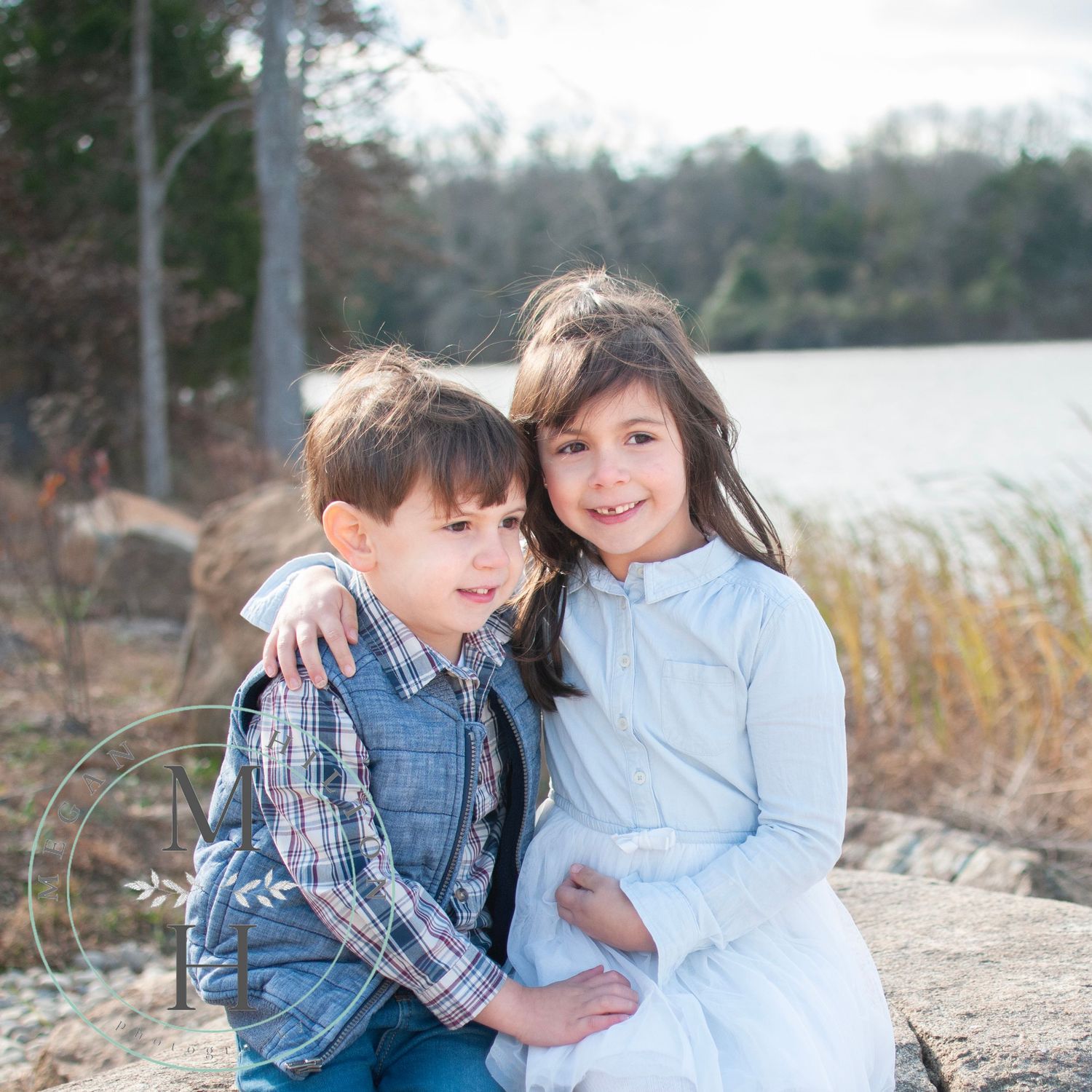Photo of two children sitting together looking away from the camera