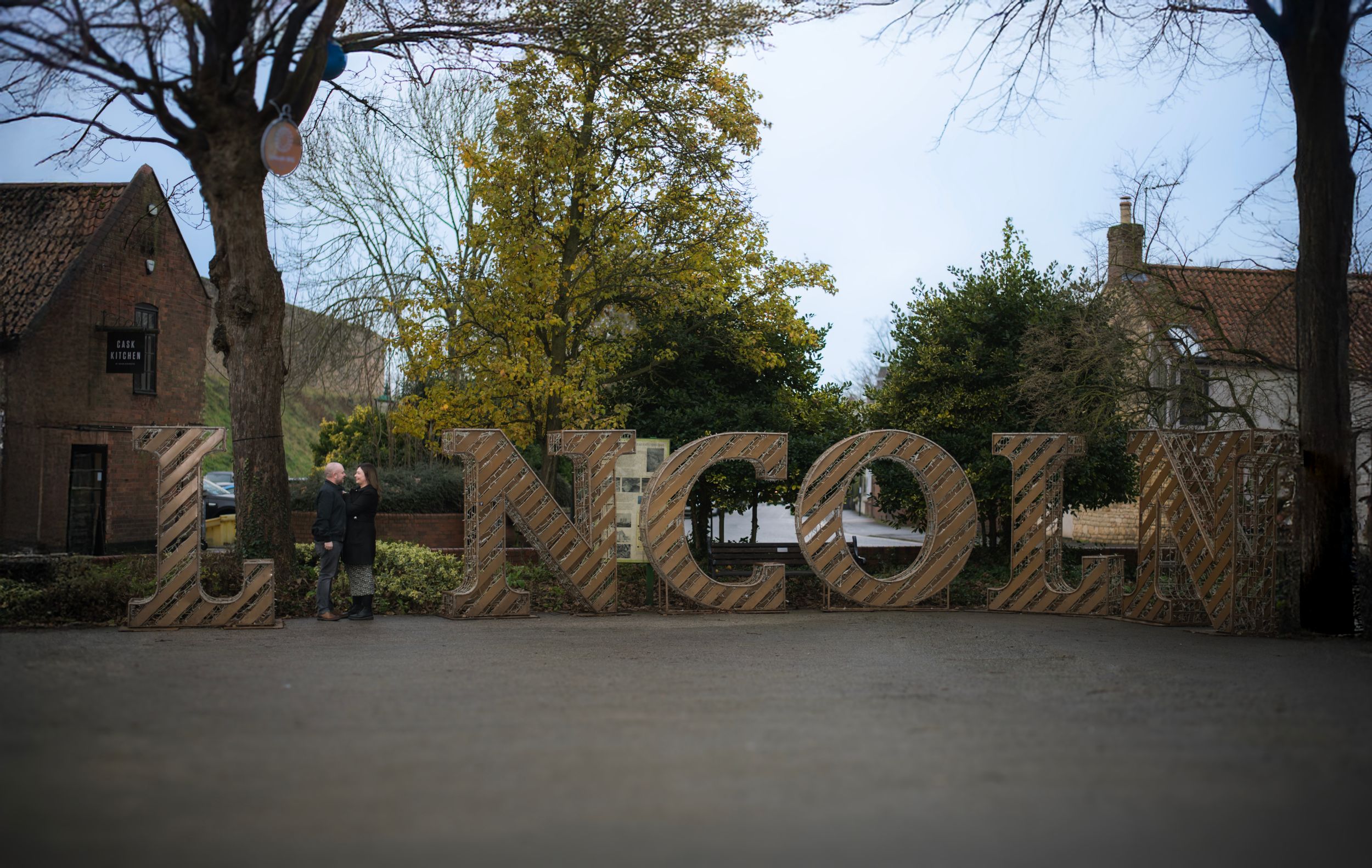 Large decorative LINCOLN text signage displayed outdoors with trees and buildings in background.