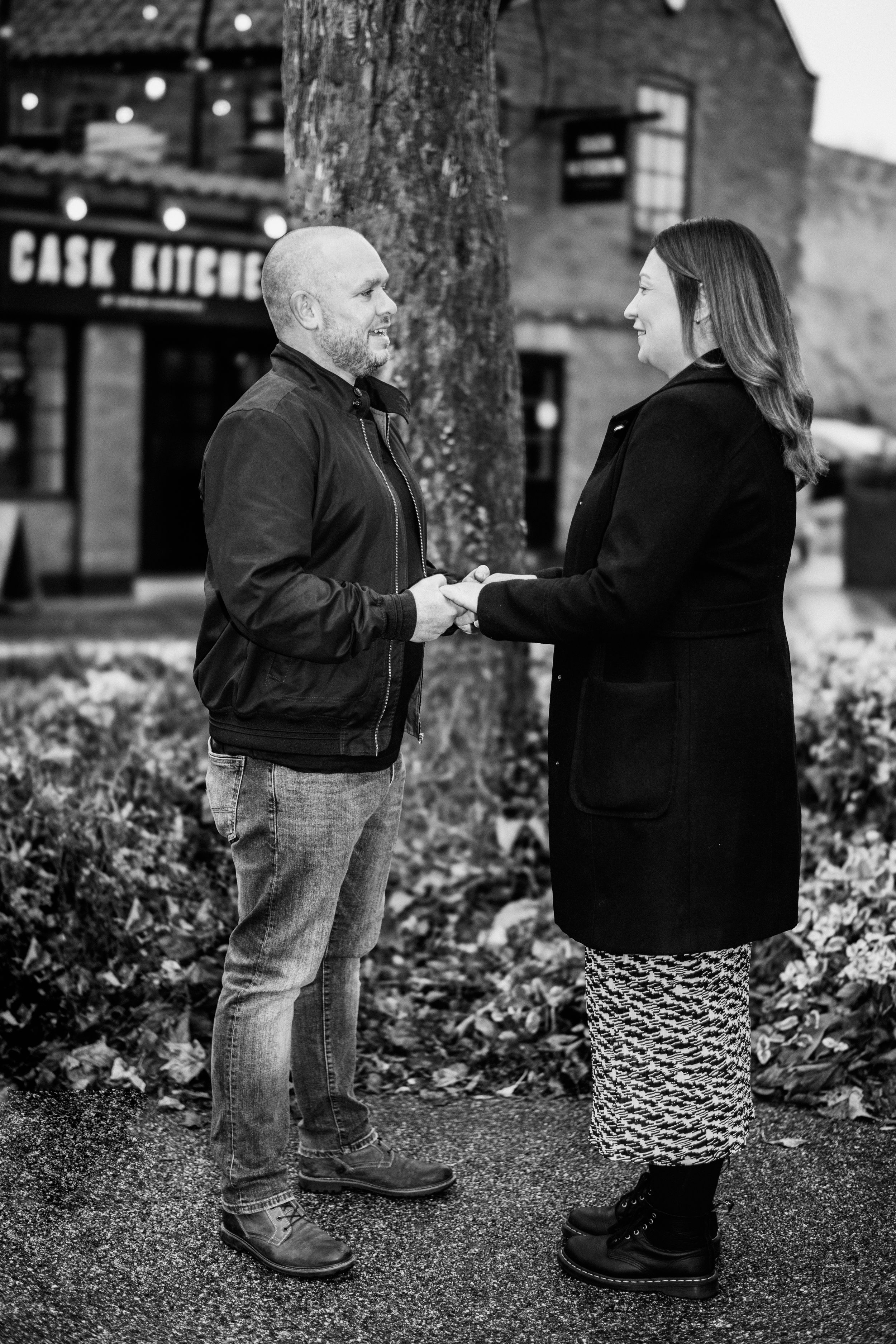 A couple sharing an intimate moment during an outdoor photoshoot in black and white.