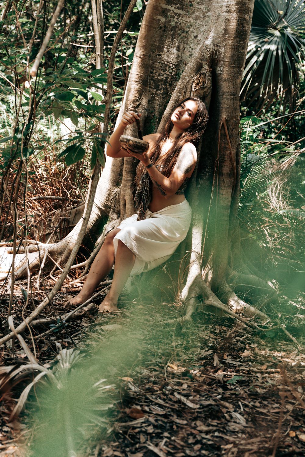 Outdoor photography session featuring a white dress against a natural forest backdrop.