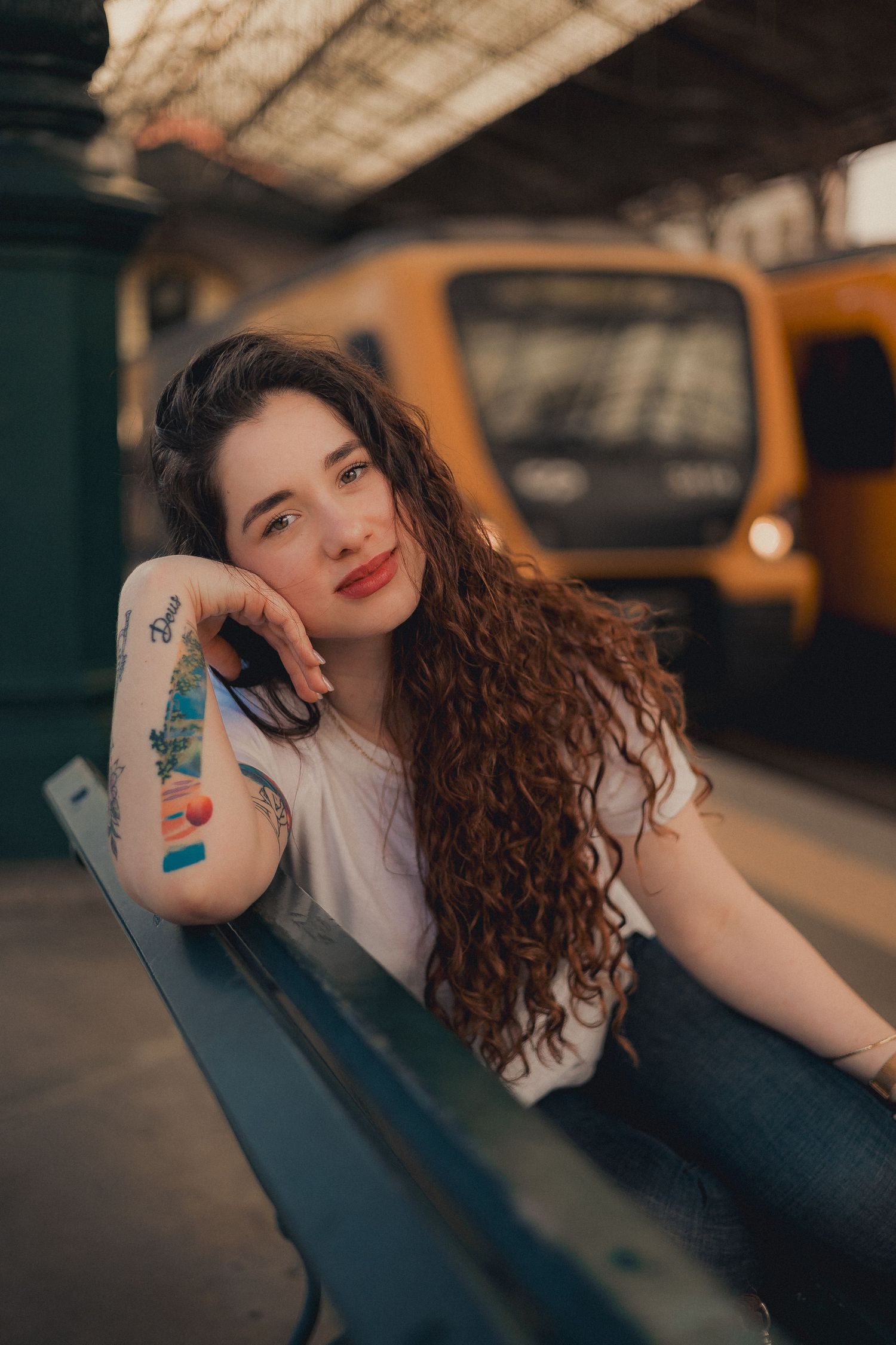 Moody train station photoshoot featuring casual poses and dramatic lighting.