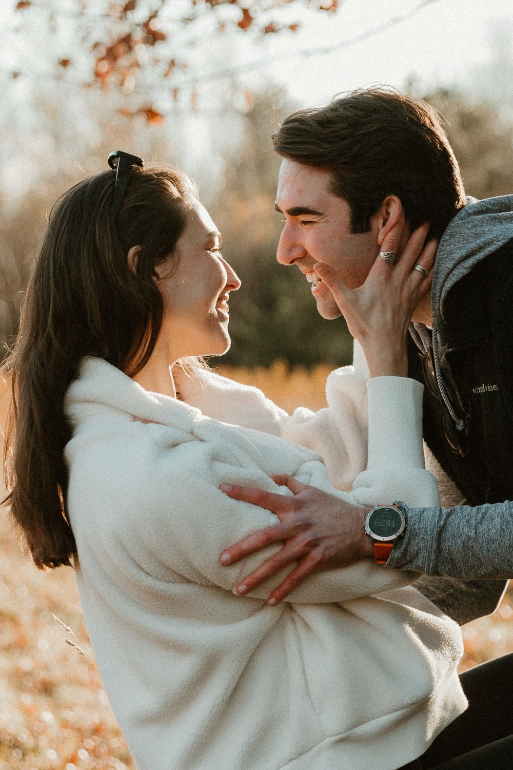 A joyful embrace captured in warm sunset light with autumn colors in the background.
