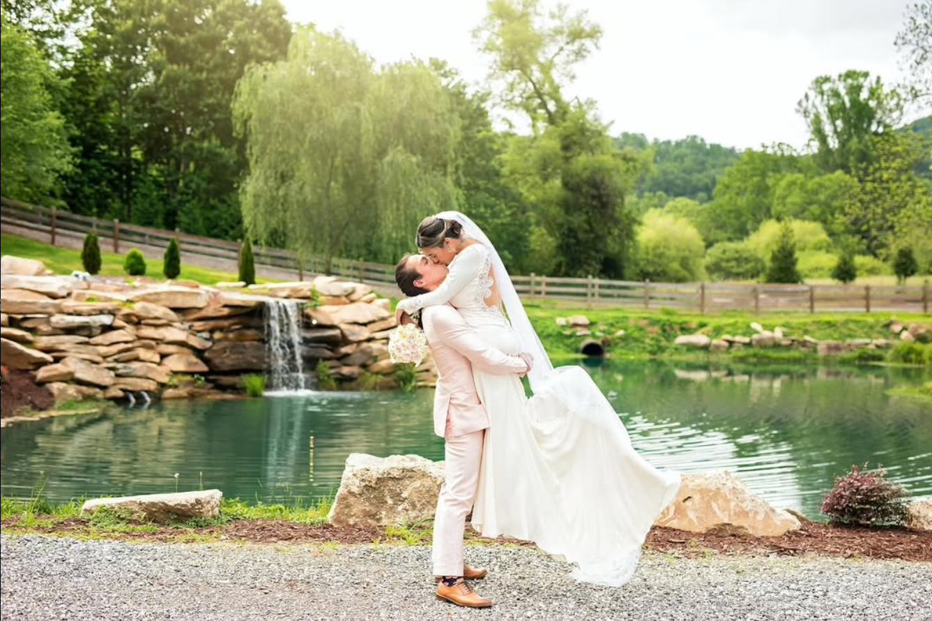 Scenic wedding photo at a waterfall location with flowing white dress.