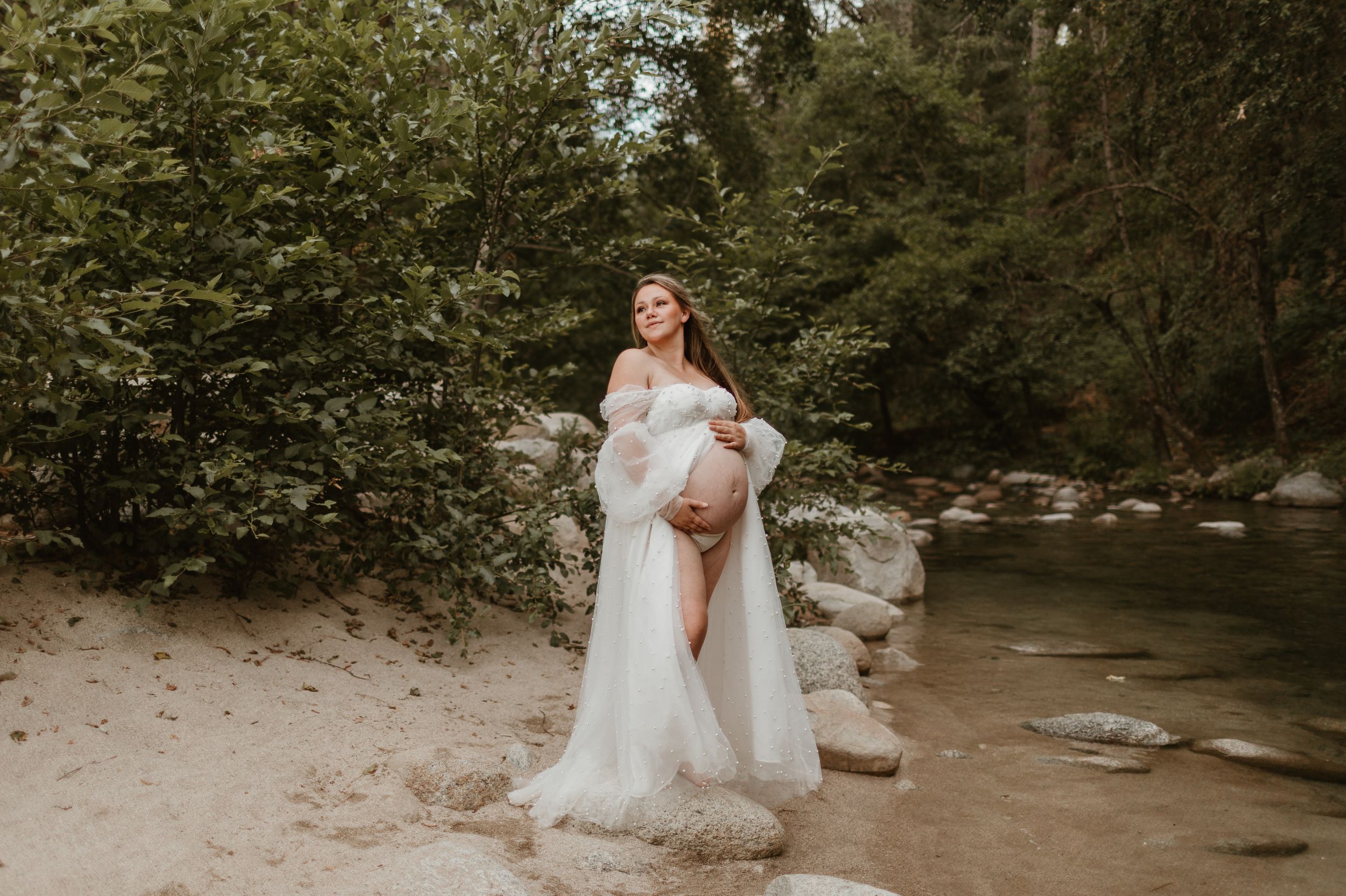 A romantic outdoor photo session in a wooded creek setting with flowing dresses and natural scenery.