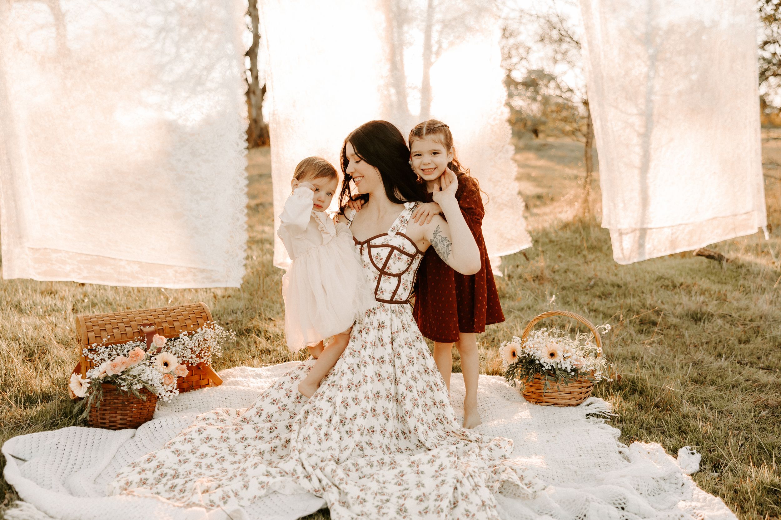 Dreamy backlit maternity photography with white linens and floral dress.