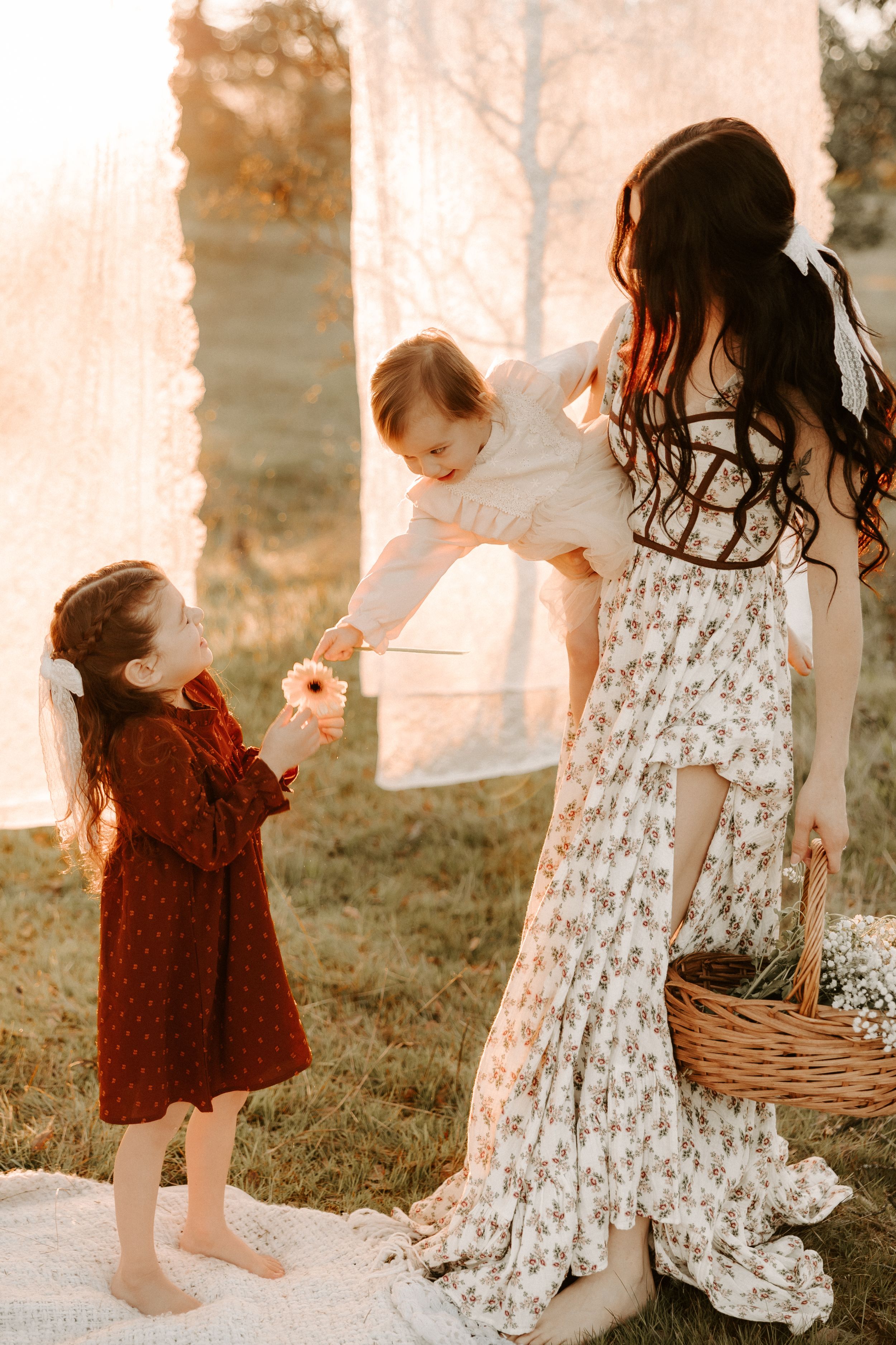 Sweet maternity moment captured between mother and child among hanging laundry.