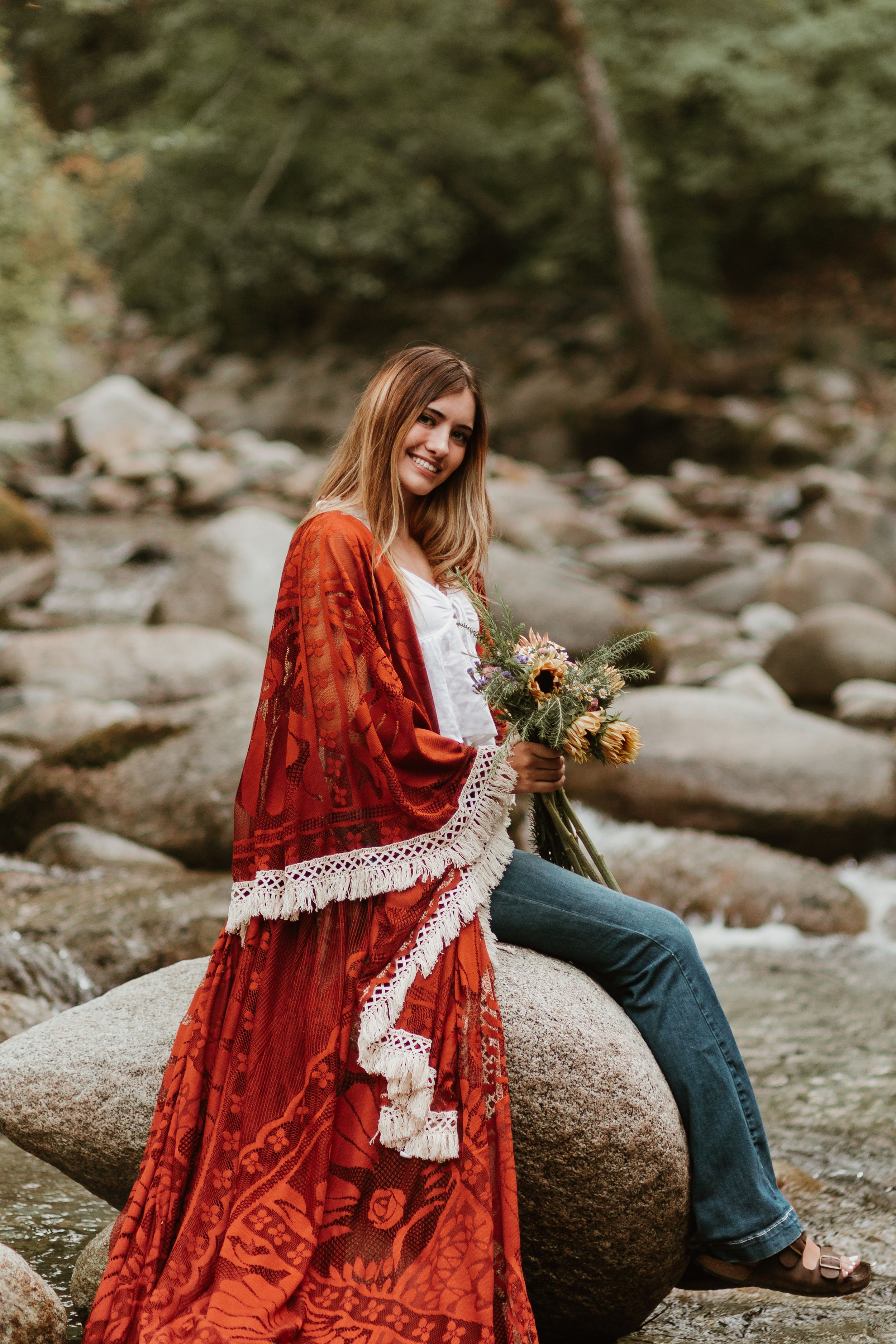 A rust-colored velvet dress with lace trim is styled for a riverside photoshoot.