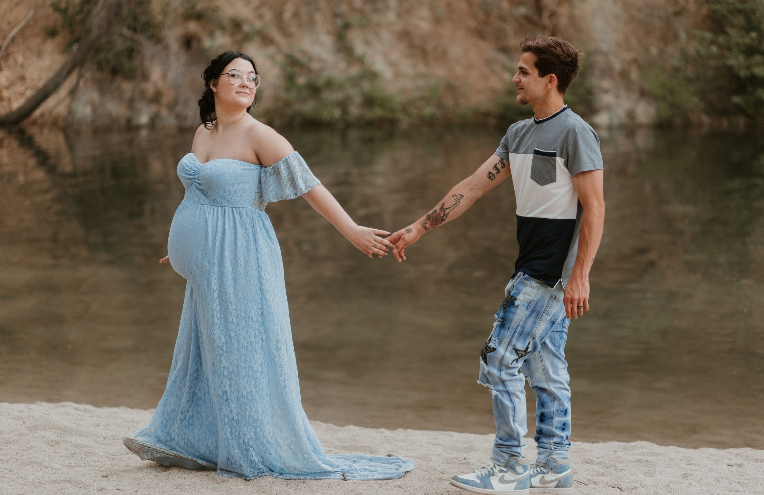 Couple sharing intimate moments along a creek bed with rocks and flowing water.
