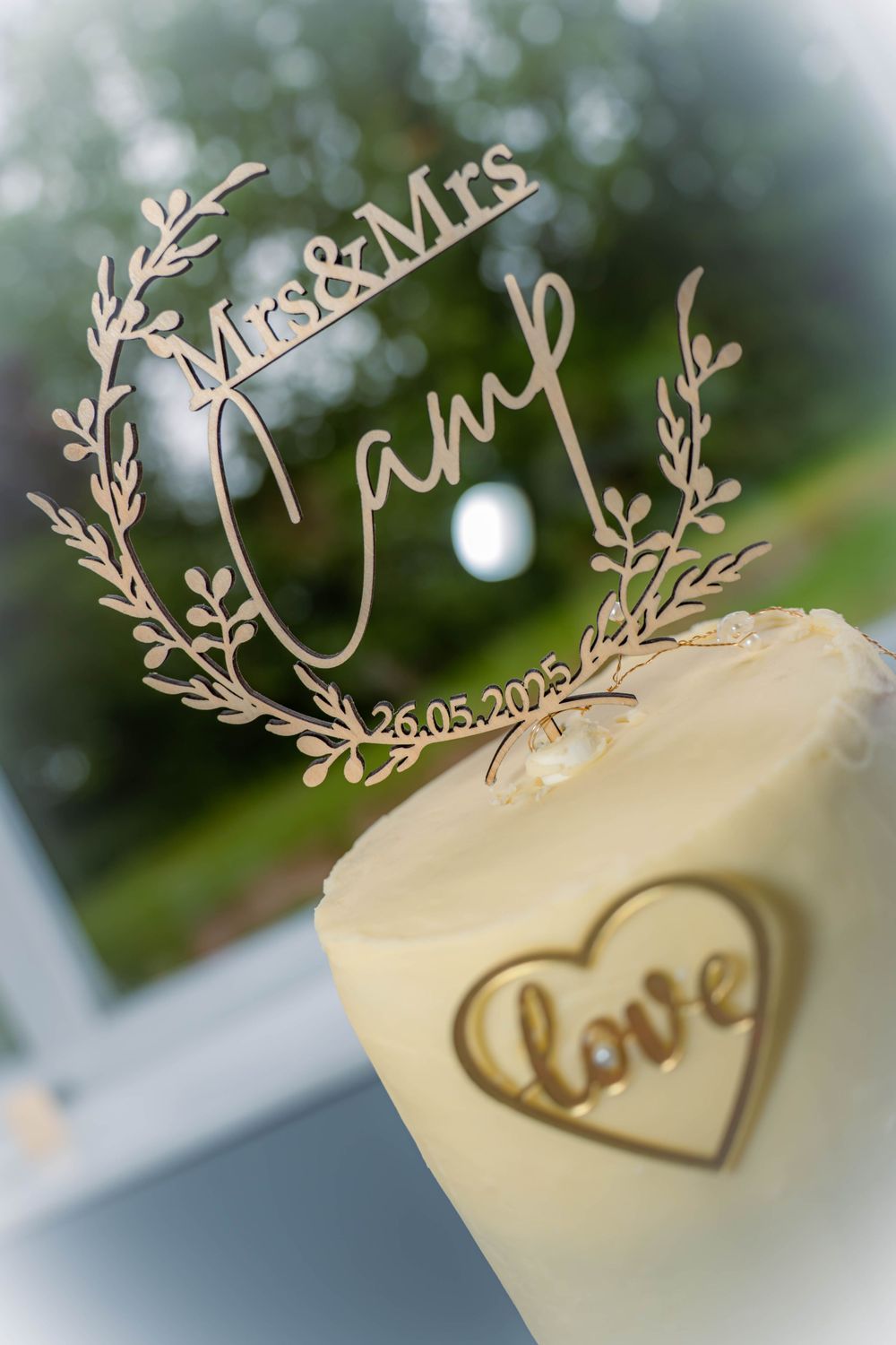 A wedding decoration showing 'Mr&Mrs' text with a date and a candle with 'love' heart design in soft focus.