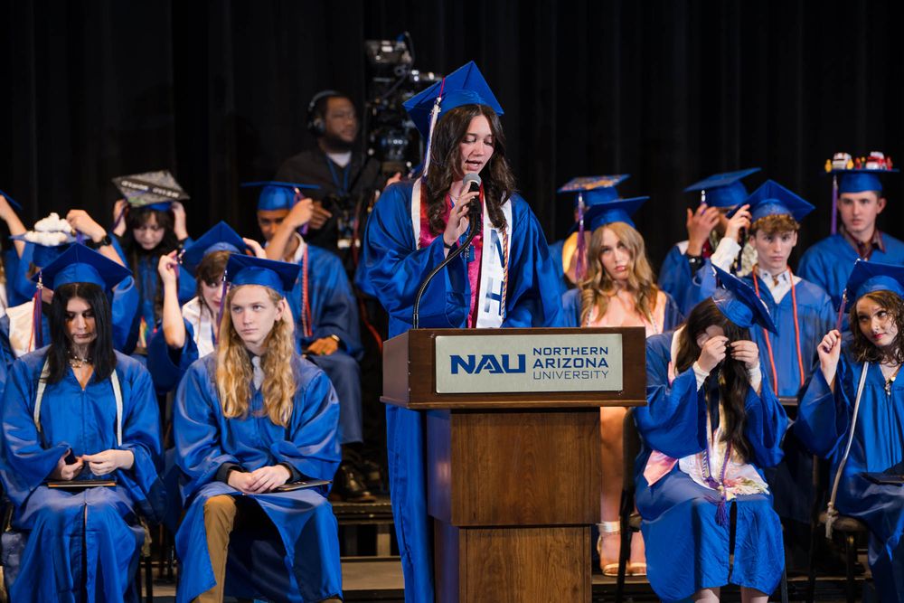 Graduate Annabelle Jackson leads classmates in moving tassels from right to left, symbolizing their transition to graduates.