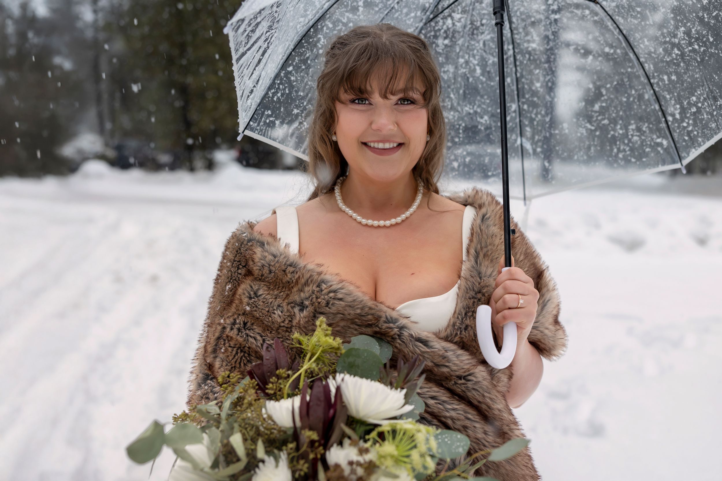 snowy winter elopement in Idaho City bride with clear umbrella