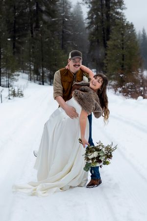 snowy winter elopement in Idaho City groom dipping bride