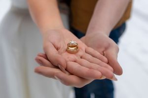 rings in hands snowy winter elopement in Idaho City