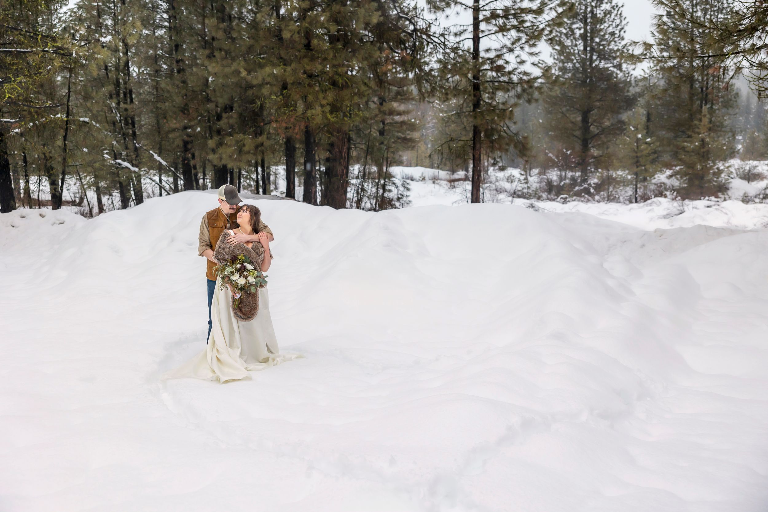 snowy winter elopement in Idaho City bride and groom standing in heart shape in the snow