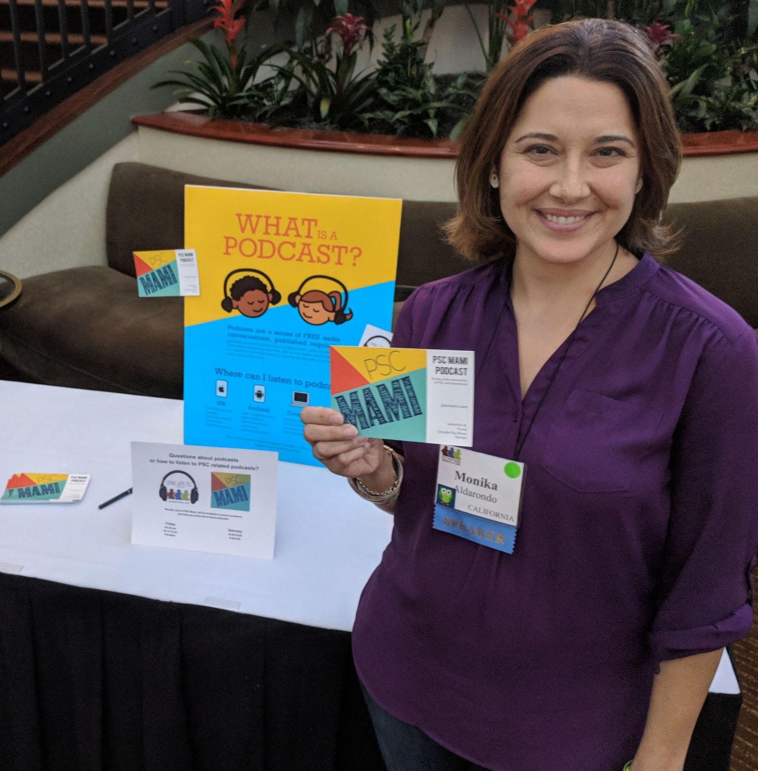 Someone in a purple shirt displays children's educational materials and learning resources at an event.
