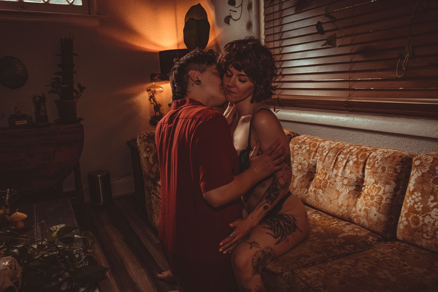 Intimate couple portrait in moody lighting with vintage-style decor.
