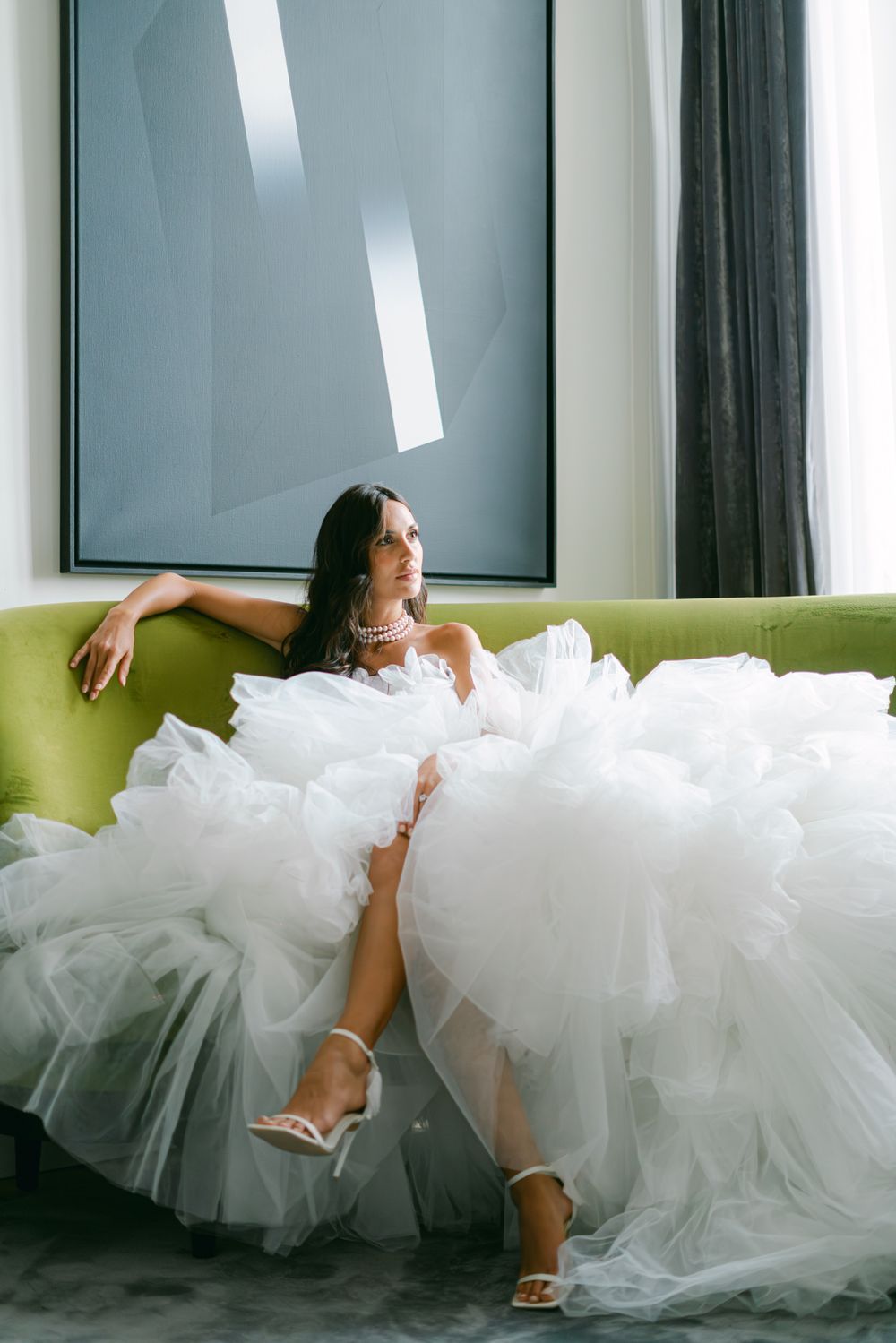 Wedding dress portrait featuring dramatic tulle skirt against modern geometric artwork.