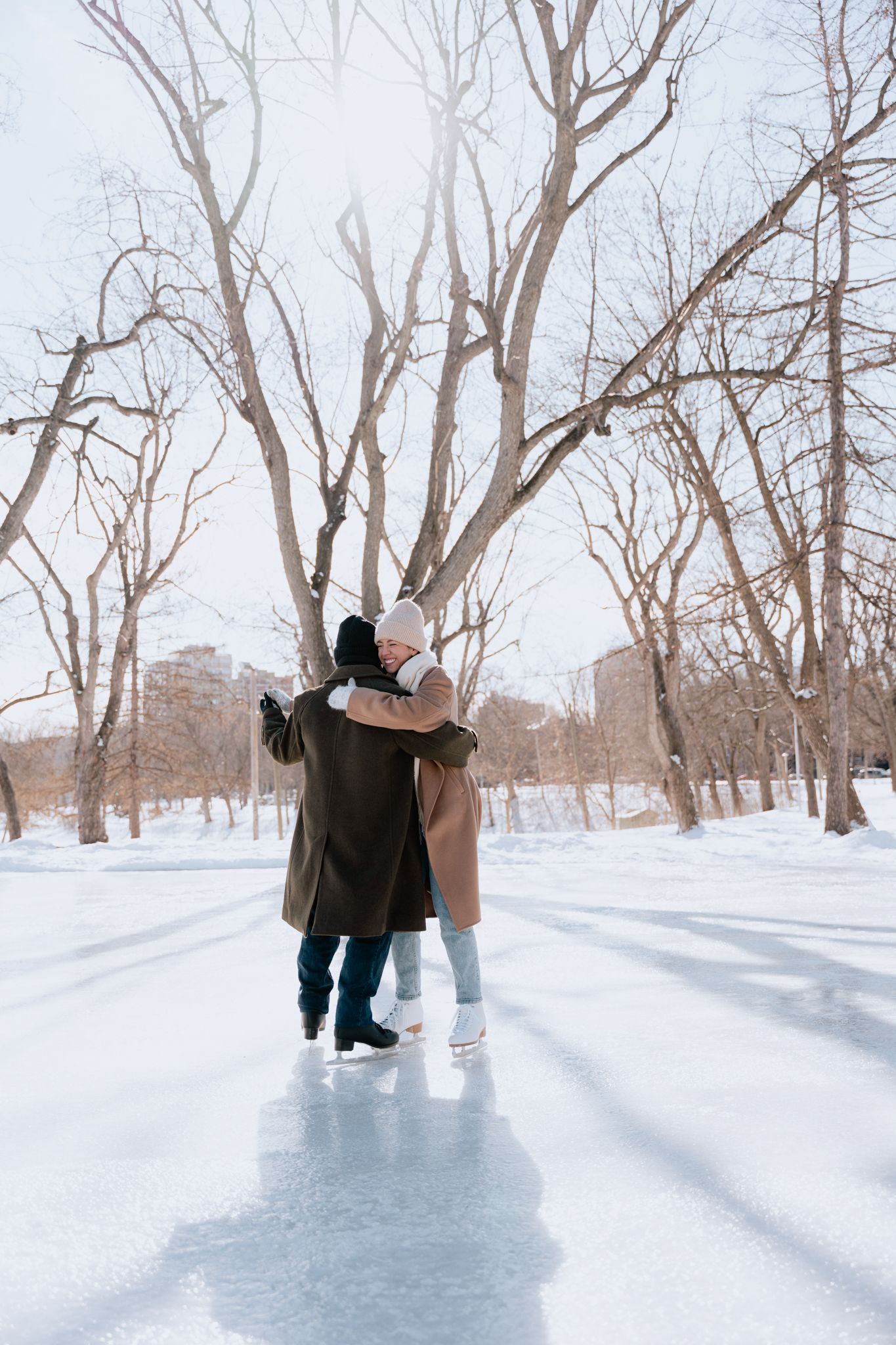 Couple en train de faire du patin à glace pendant une séance photo en hiver au parc La Fontaine à Montréal.