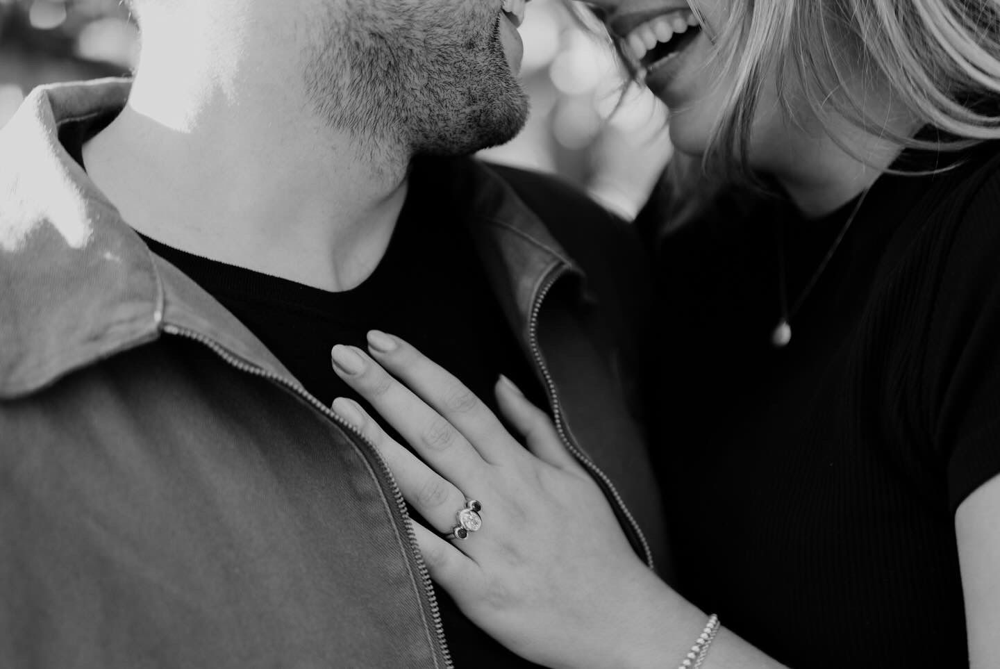 Black and white engagement photo with joyful laughter.
