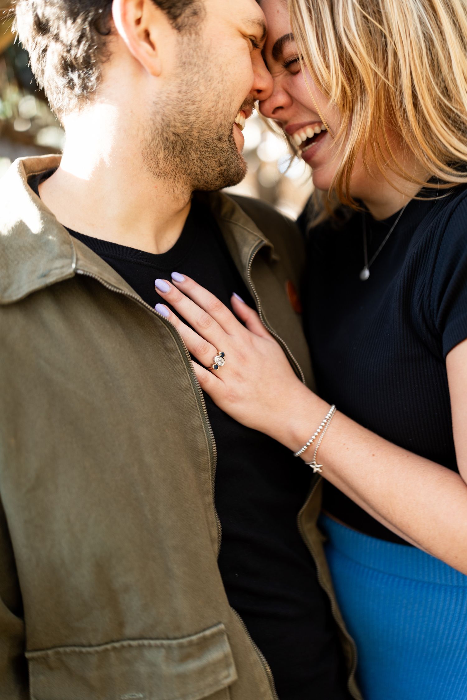 Romantic couple sharing intimate moment against dark background in warm lighting.