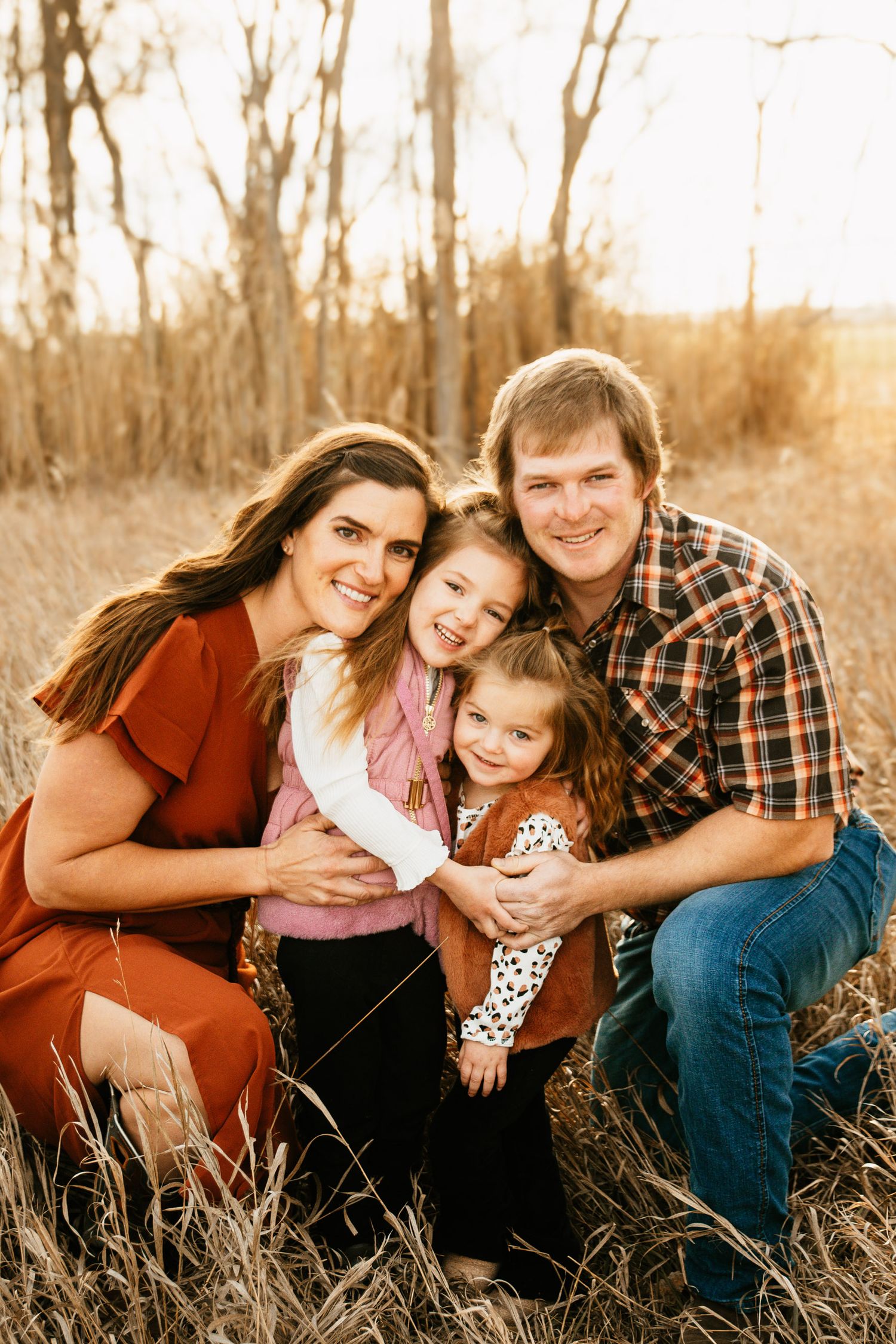 Group portrait in tall grass during golden hour.