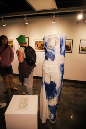 Art gallery exhibition showing large blue and white abstract pieces mounted on walls.