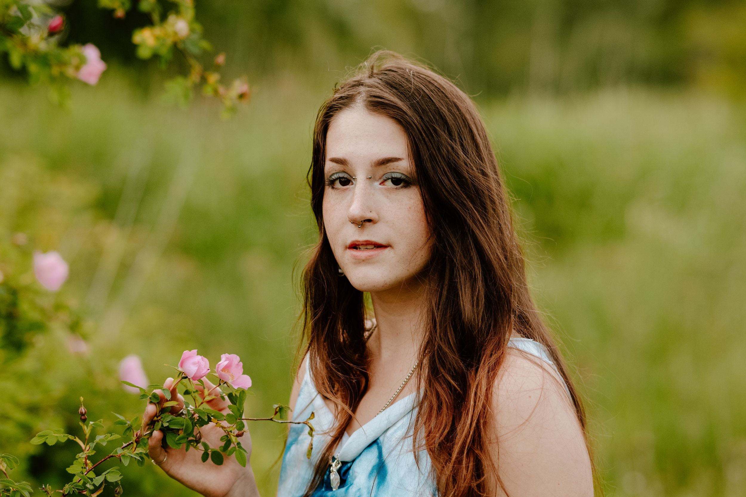 Series of outdoor portraits in a green meadow with wildflowers and soft natural lighting.
