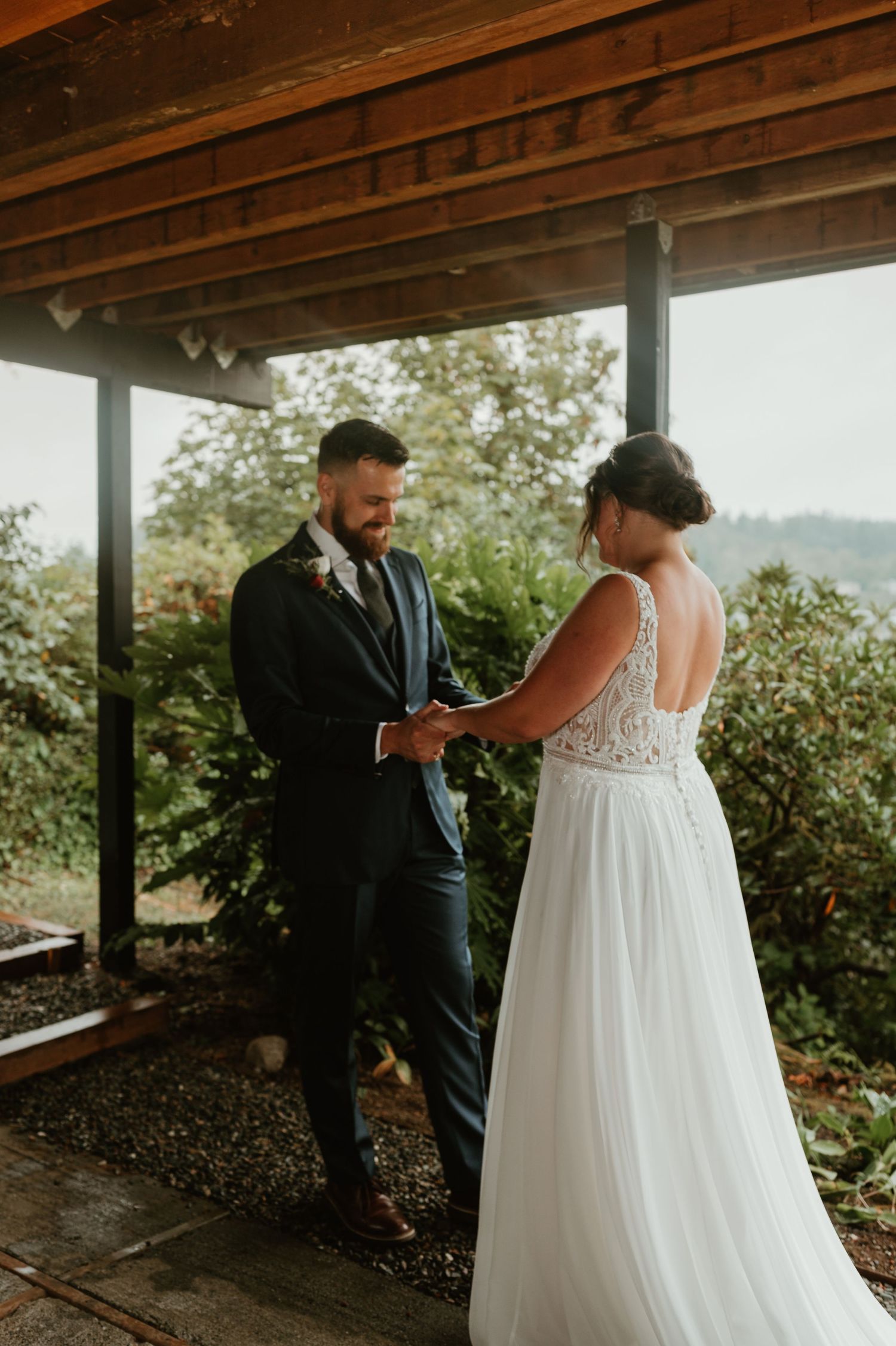 Wedding ceremony moment under covered porch with mountain vista.