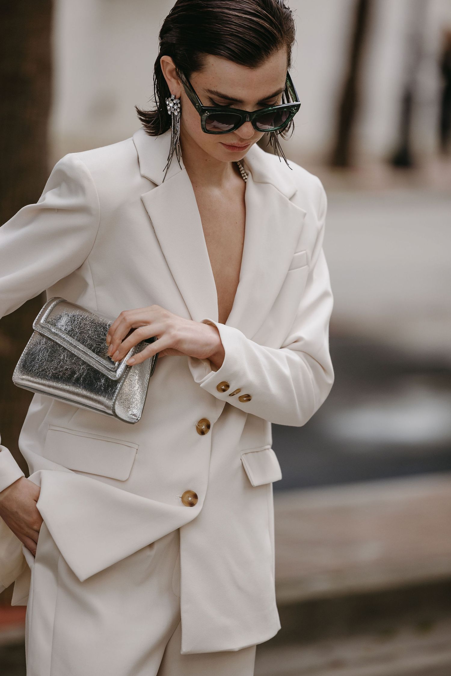 Sophisticated white blazer suit styled with sunglasses and metallic clutch.