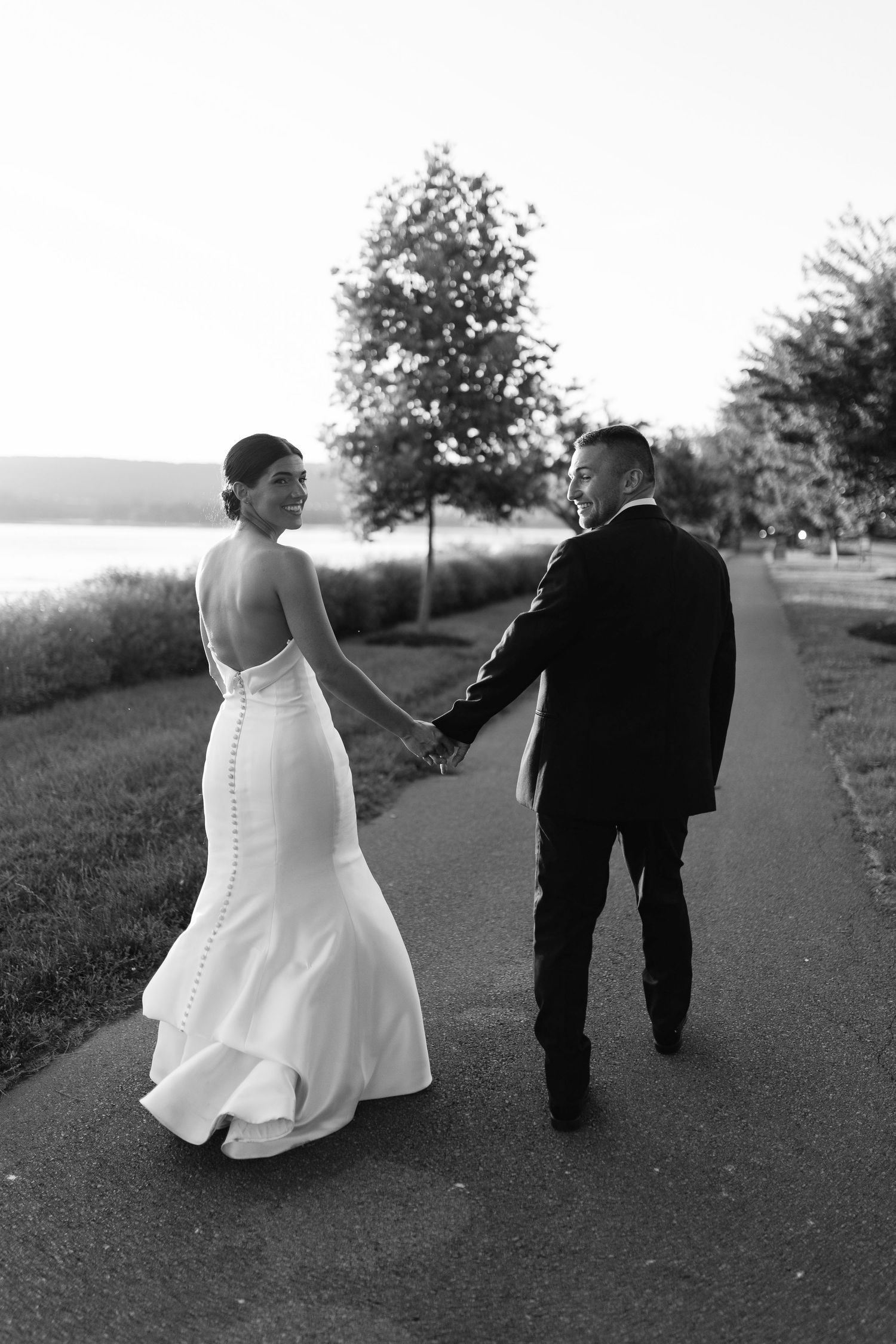 Black and white wedding sequence showing couple walking along scenic path.