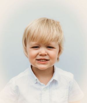 A simple studio portrait against a light gray background.