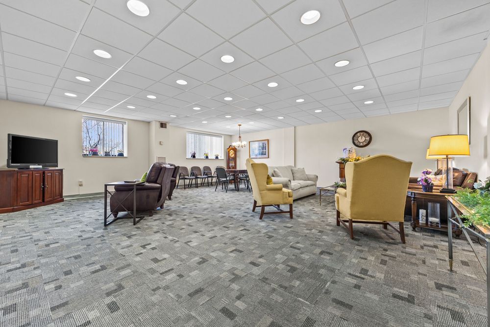 Comfortable community lounge with carpeted floors, seating area, and recessed ceiling lighting.