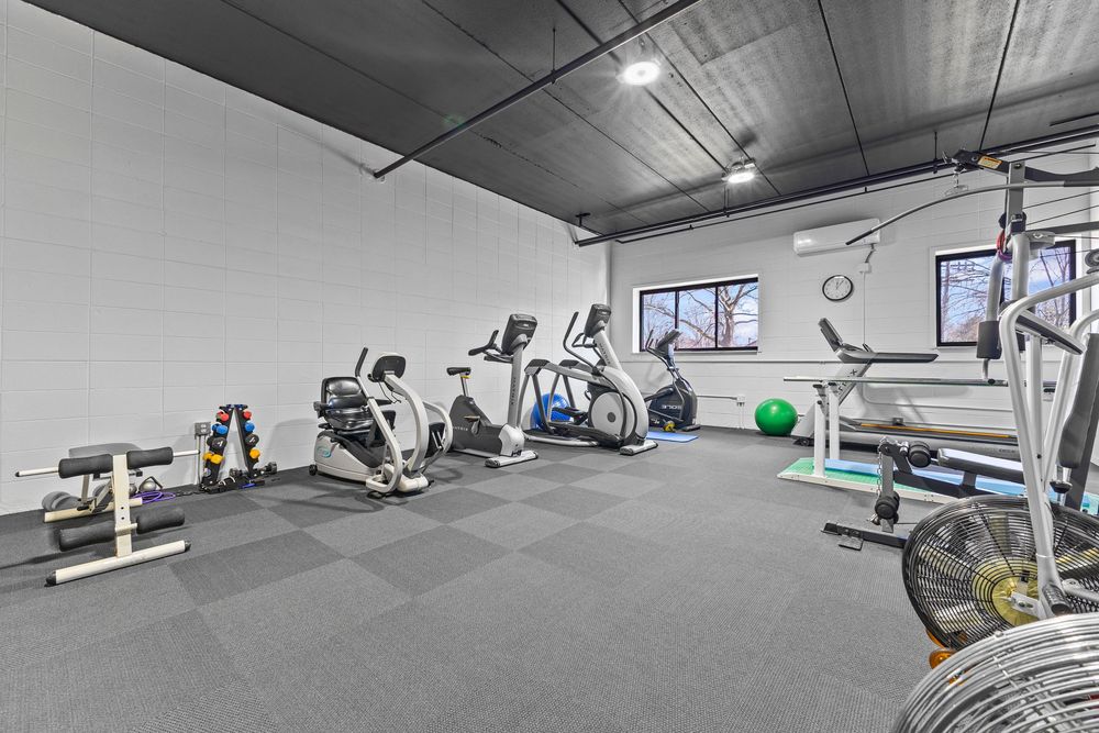 Spacious gym facility featuring cardio equipment, free weights, and rubber tile flooring.