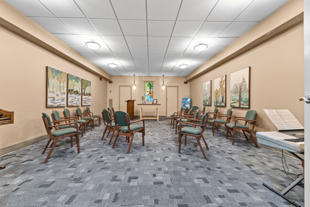 Bright community meeting room with circular chair arrangement and artwork at Morley Manor Cooperative.