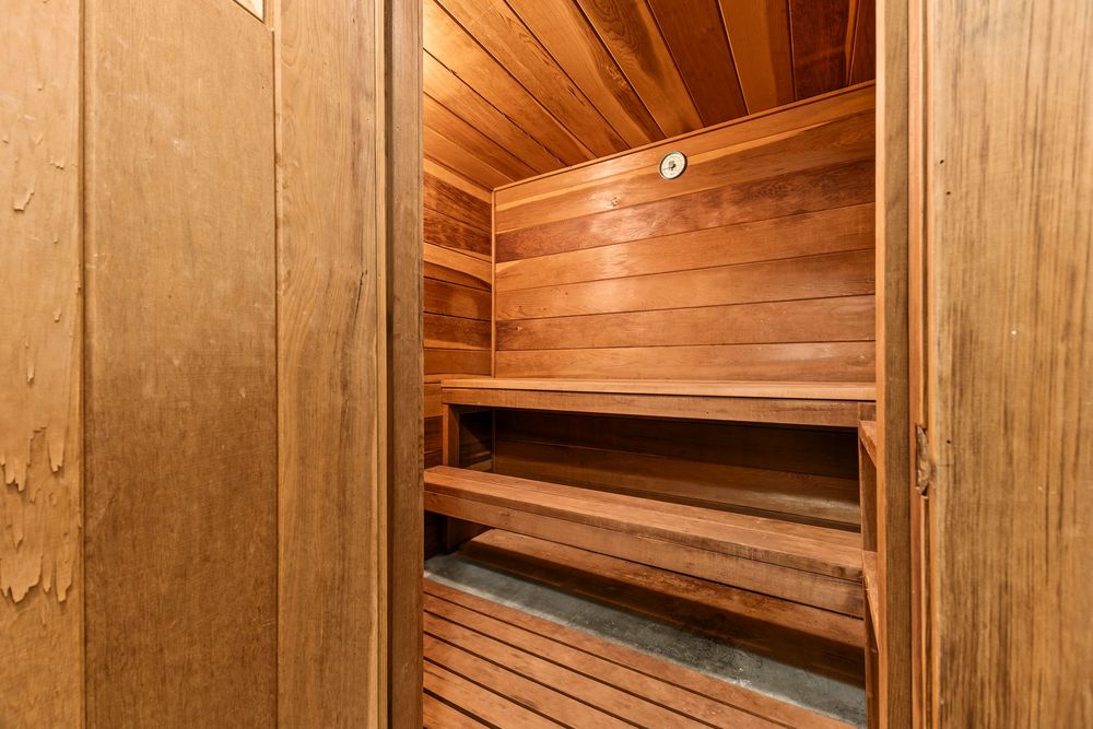 Cozy cedar wood sauna with tiered benches and warm lighting inside Morley Manor Cooperative.