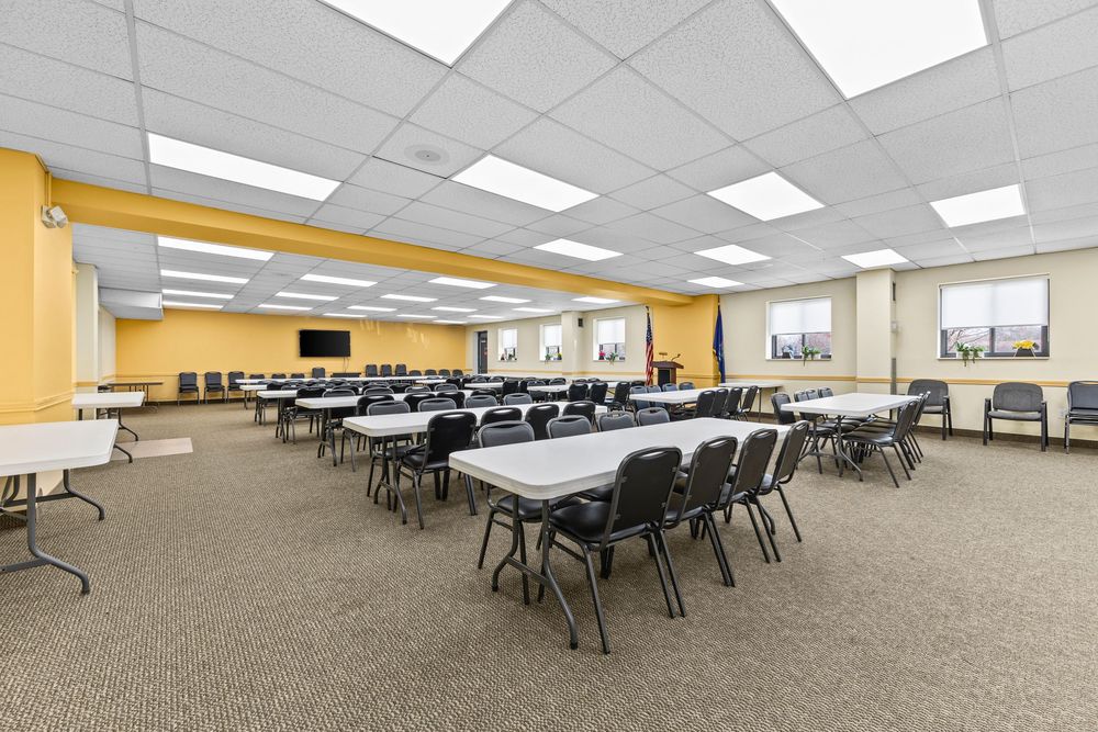 Large carpeted conference room with folding tables and chairs at Morley Manor Cooperative Inc.