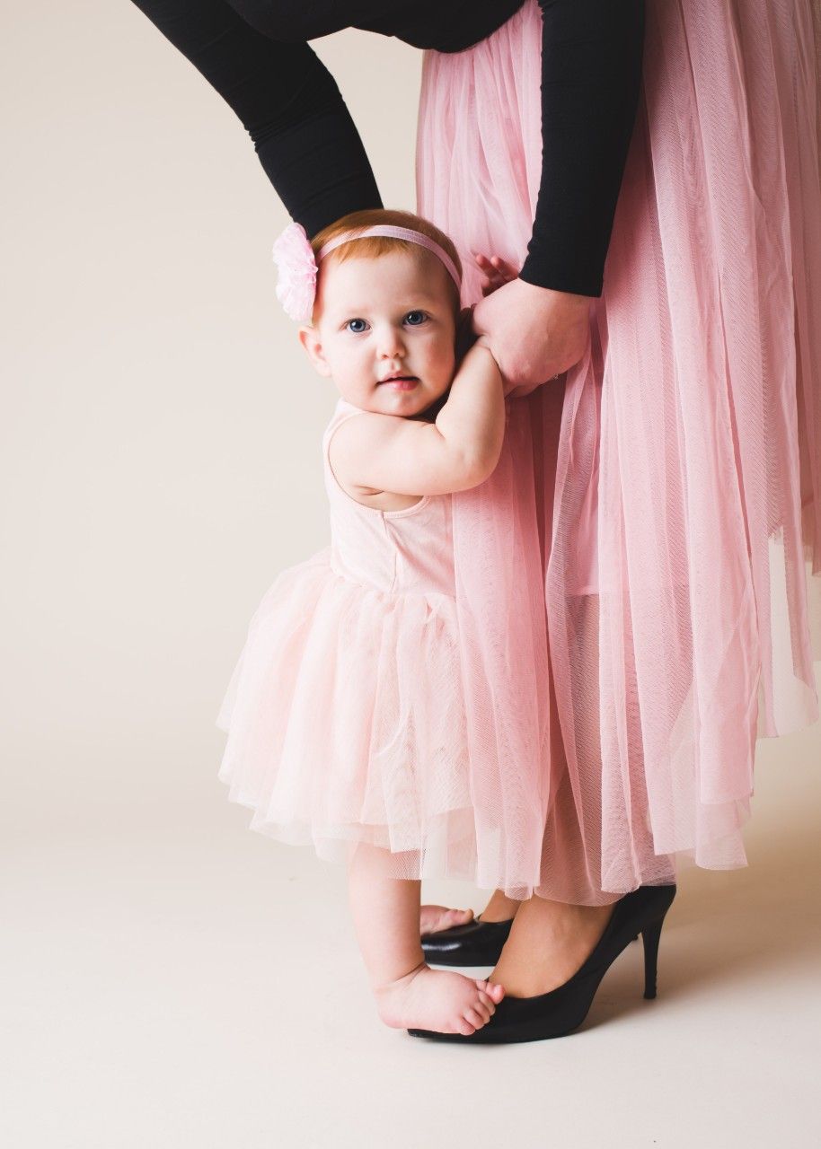 Mother holding her young daughter by the hand during a portrait session